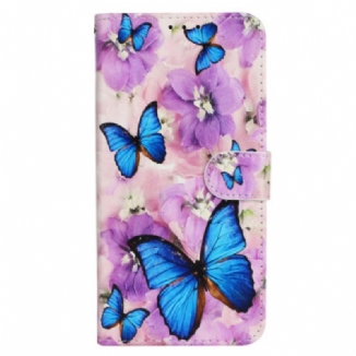 Housse iPhone 16 Papillons Bleus et Fleurs Violettes à Lanière