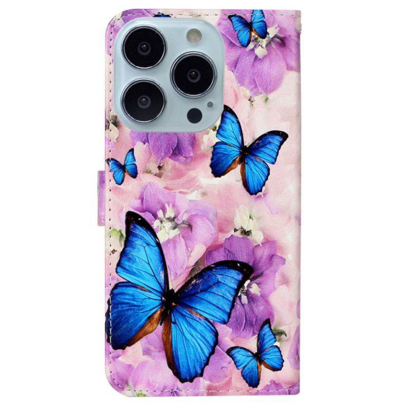 Housse iPhone 16 Pro Papillons Bleus et Fleurs Violettes à Lanière